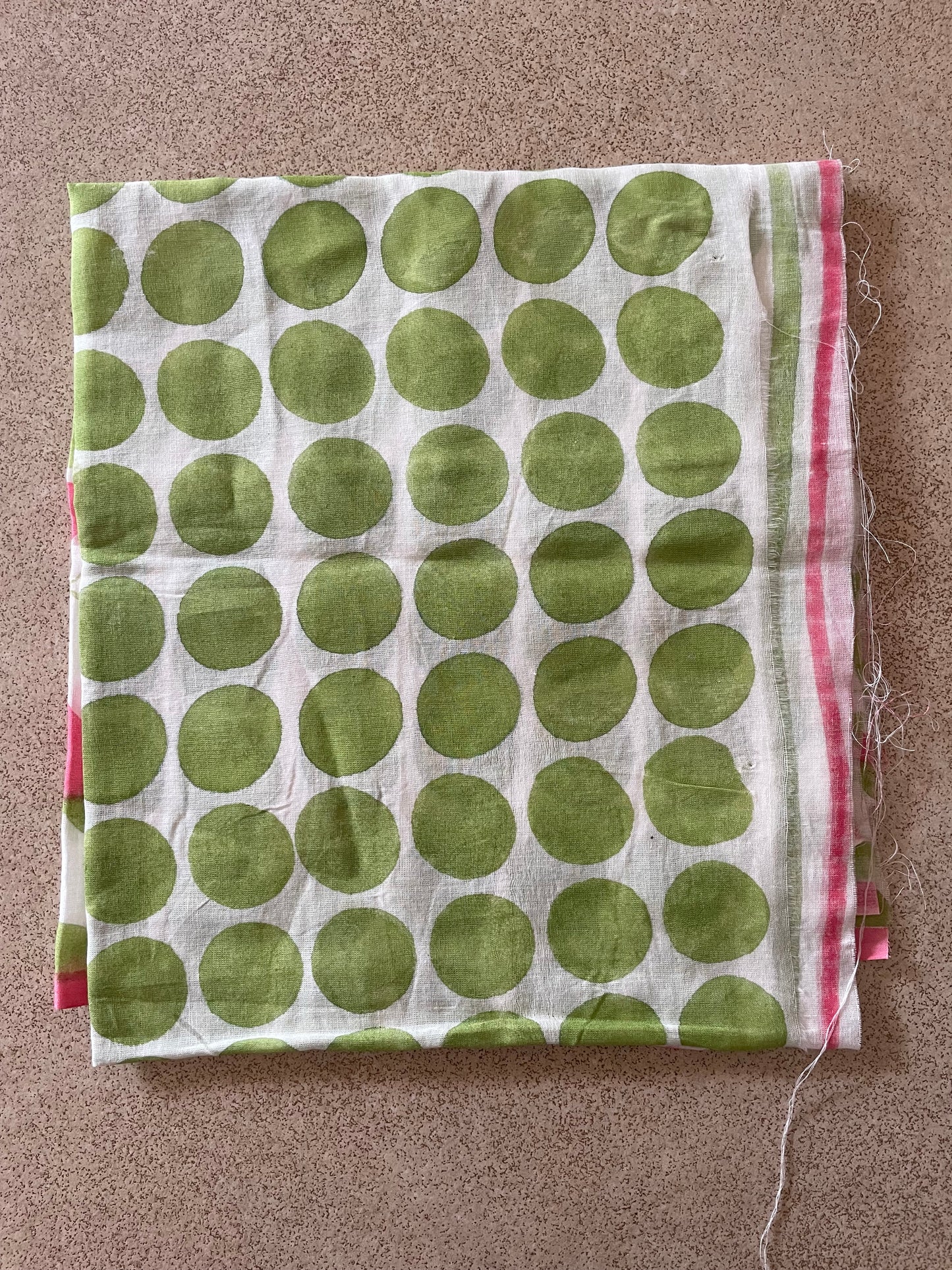 Mogasu blouse piece with green polka dots on a brown background.