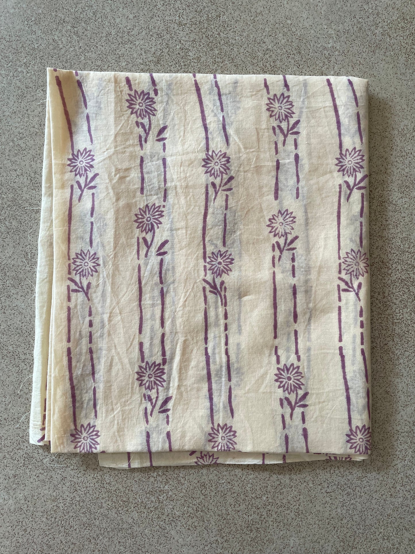 Folded Mogasu saree blouse piece with floral patterns on a gray surface