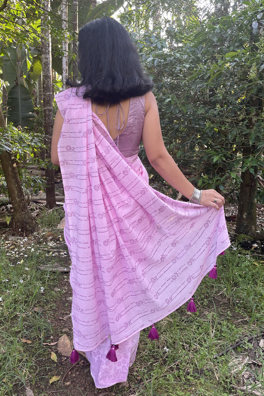 Woman in a Mogasu pink saree with florals walking through a forest in Goa