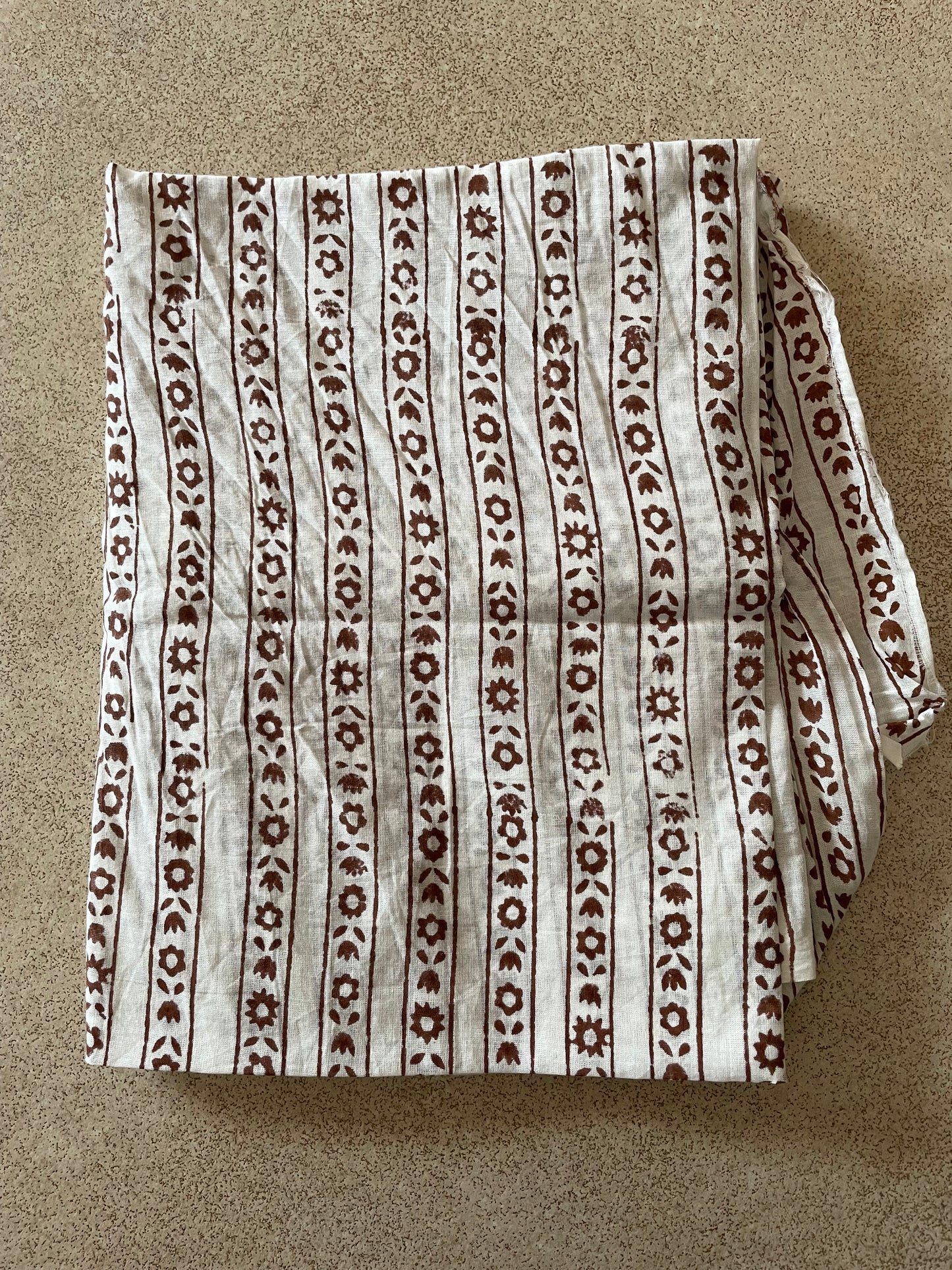 Folded Mogasu blouse piece with a brown pattern on a beige background