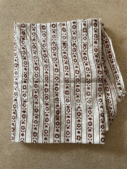 Folded Mogasu blouse piece with a brown pattern on a beige background