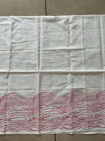 White Mogasu saree blouse piece with red wavy pattern on a beige surface.