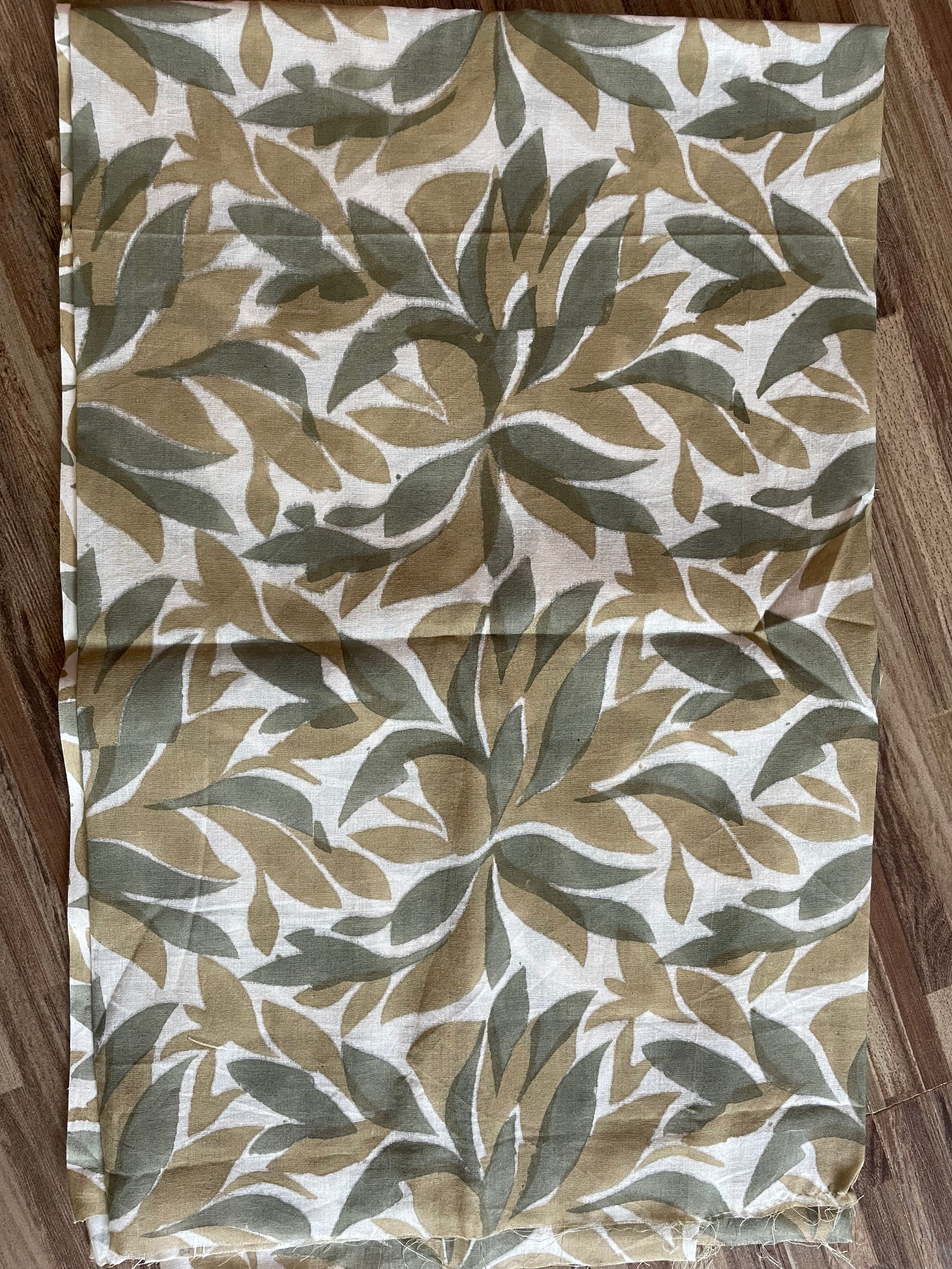 Folded Mogasu Tefal saree blouse piece with leaf pattern on a wooden surface.