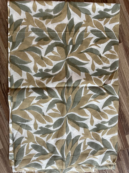 Folded Mogasu Tefal saree blouse piece with leaf pattern on a wooden surface.