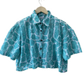 Blue patterned Mogasu shirt on a hanger against a white background