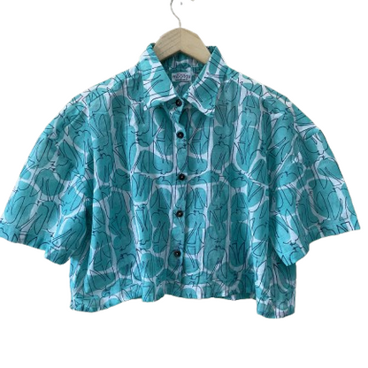 Blue patterned Mogasu shirt on a hanger against a white background