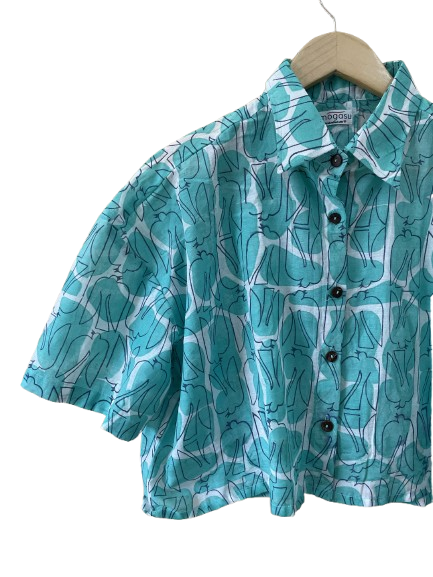 Teal patterned Mogasu shirt on a hanger against a white background