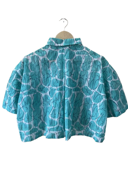 Blue patterned Mogasu shirt on a hanger against a white background