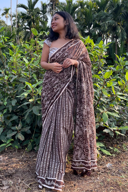 Woman in a mushroom patterned saree from Mogasu standing in a natural setting with greenery in Goa. 