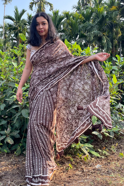 Woman in a Mushroom patterned mul cotton saree from Mogasu standing in a garden with greenery around in Goa