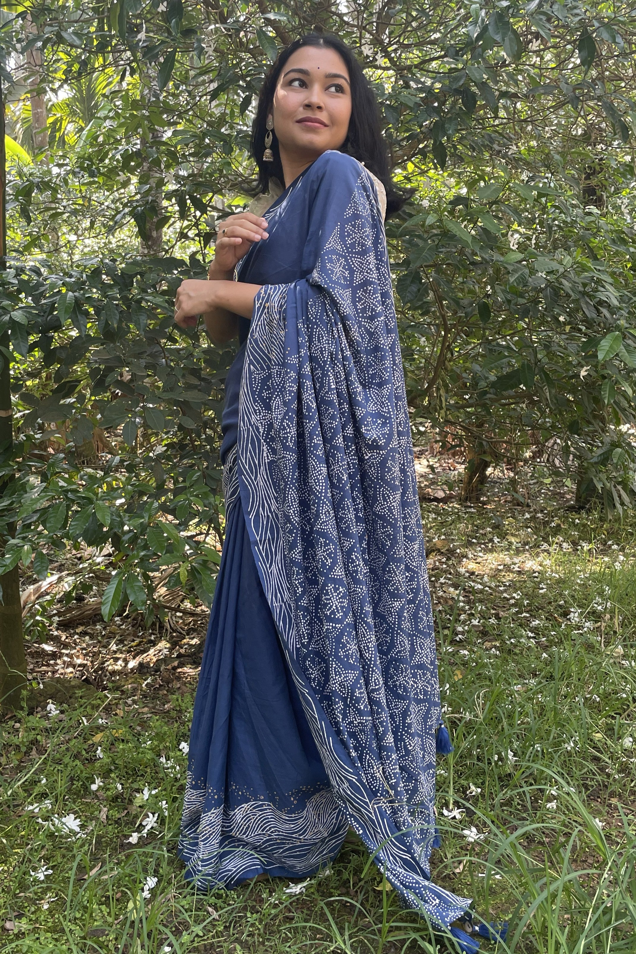 Woman in Mogasu’s blue Starry Surf saree with white patterns standing in a Spice plantation in Goa