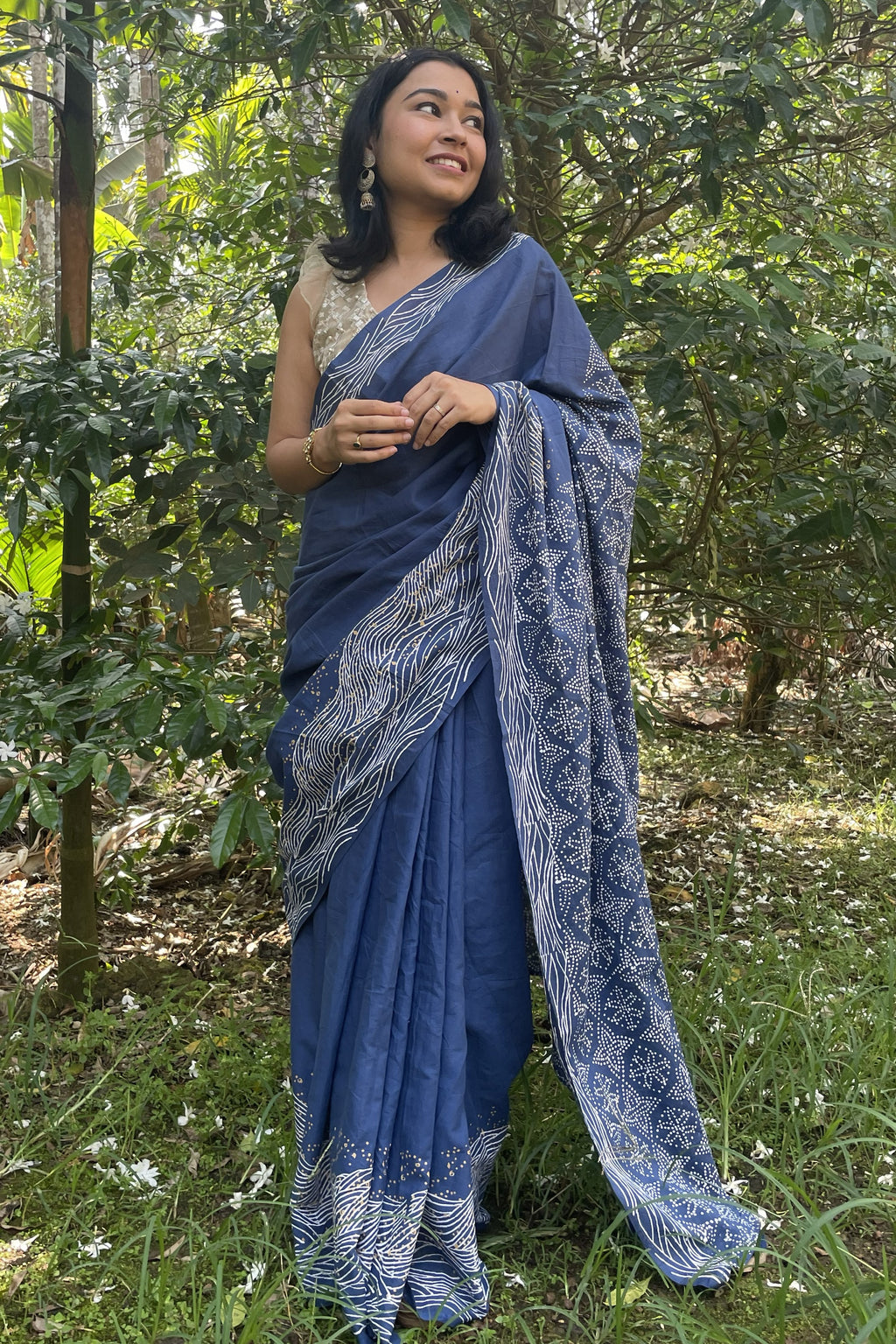 Woman in a Mogasu blue saree standing in a forest setting in Goa