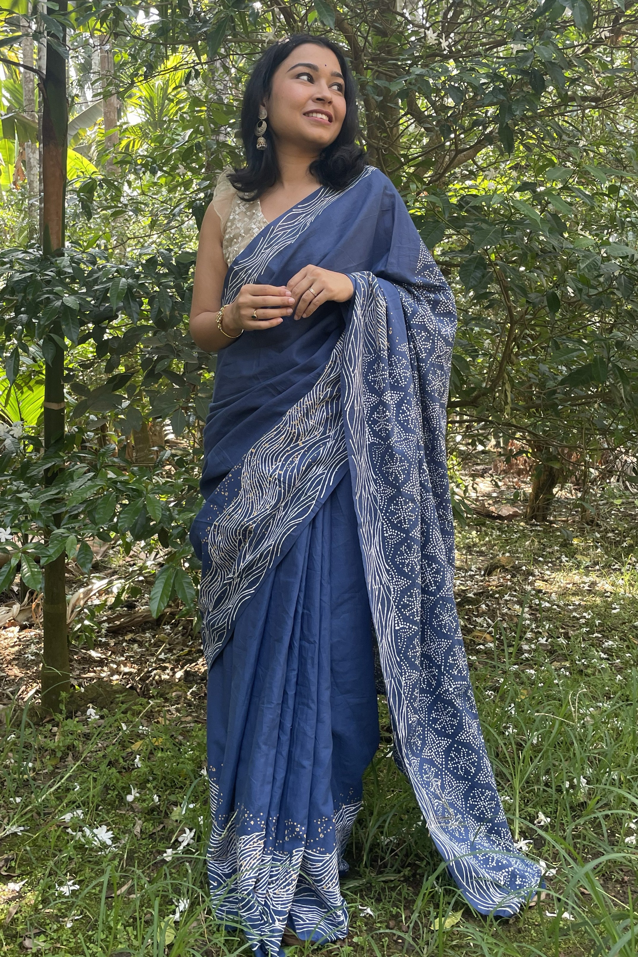 Woman in a Mogasu blue saree standing in a forest setting in Goa