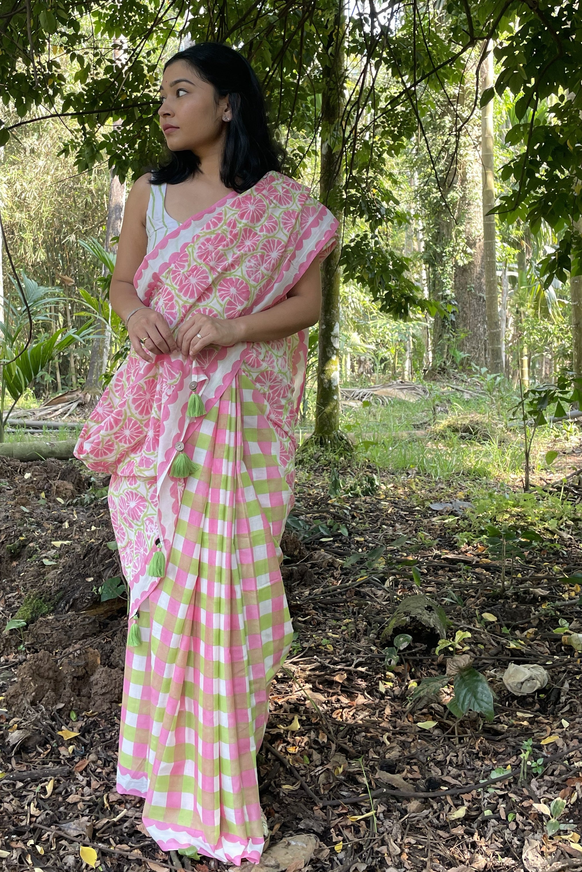 Woman in a Mogasu pink and green mul cotton saree standing in a forest setting in Goa