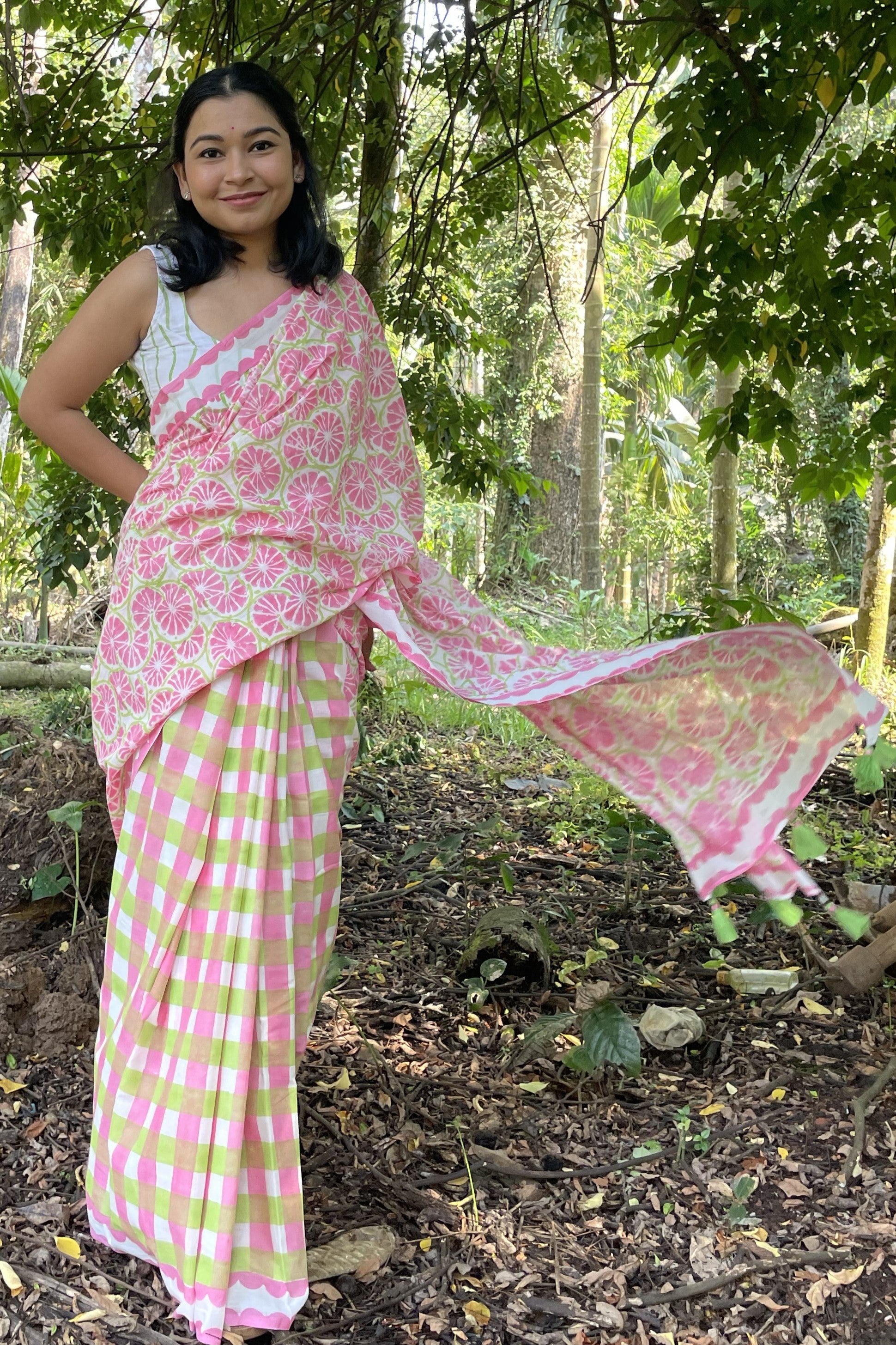 Woman in a Mogasu’s pink and green mul cotton saree standing in a forest setting in Goa
