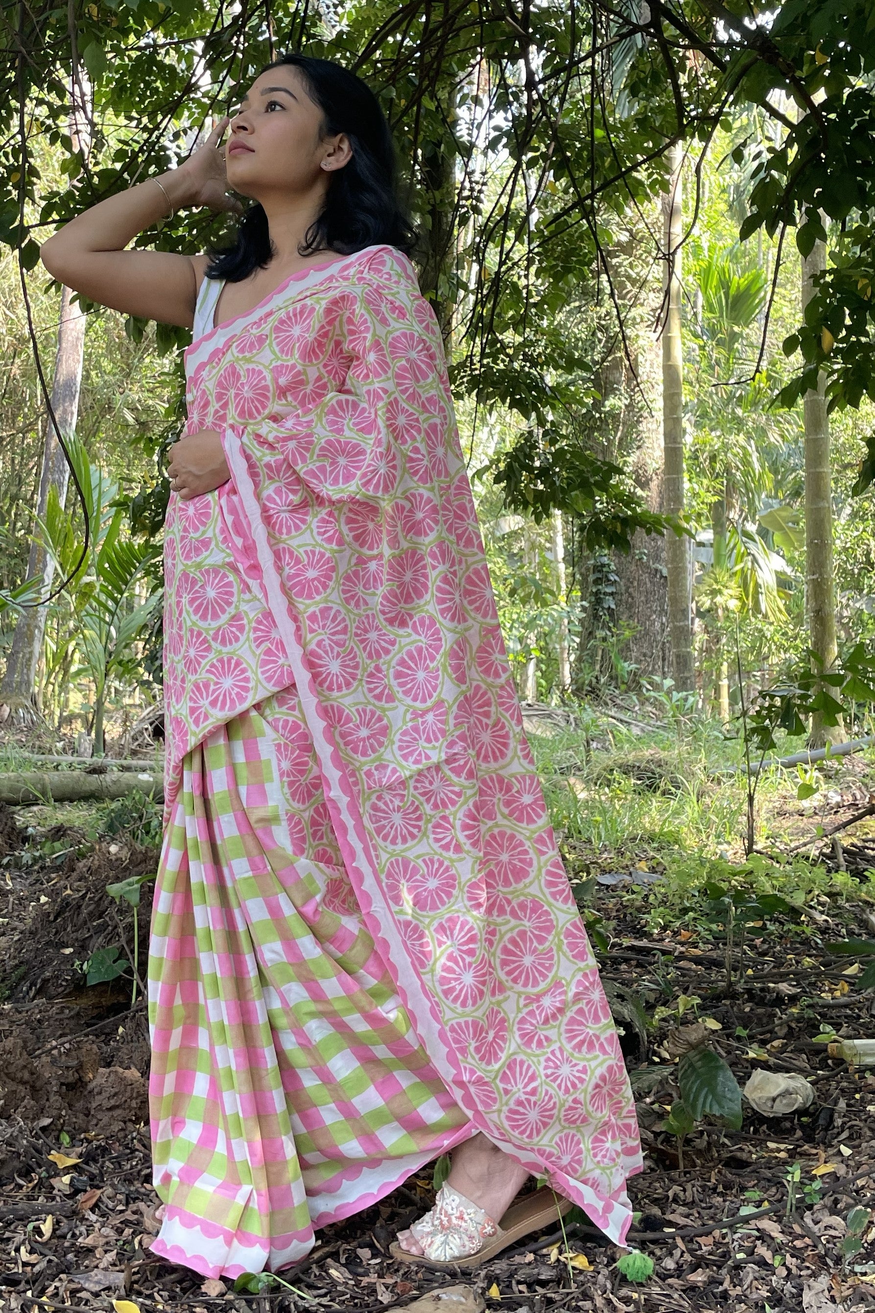 Woman in a Mogasu pink and green Toring saree standing in a forest setting in Goa.