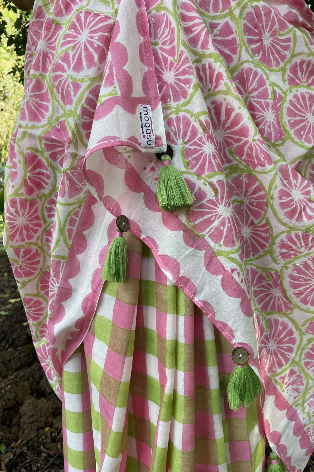 Pink and green checks patterned Mogasu saree with tassels on a natural background in Goa.
