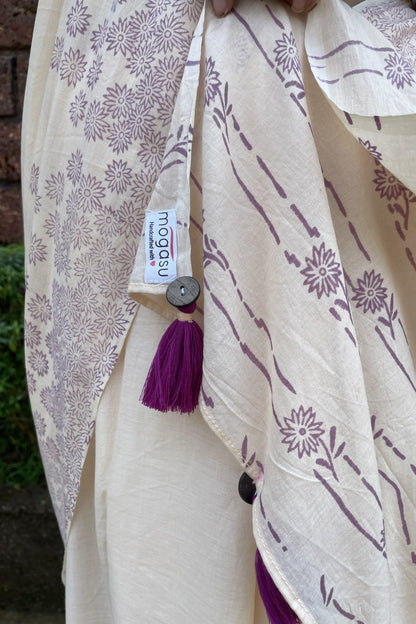 Mogasu cream mul cotton saree with purple floral patterns, tassels, and a visible brand tag.