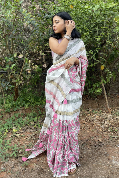 Woman wearing a Mogasu white and pink mul cotton saree with patterns in a natural setting in Goa