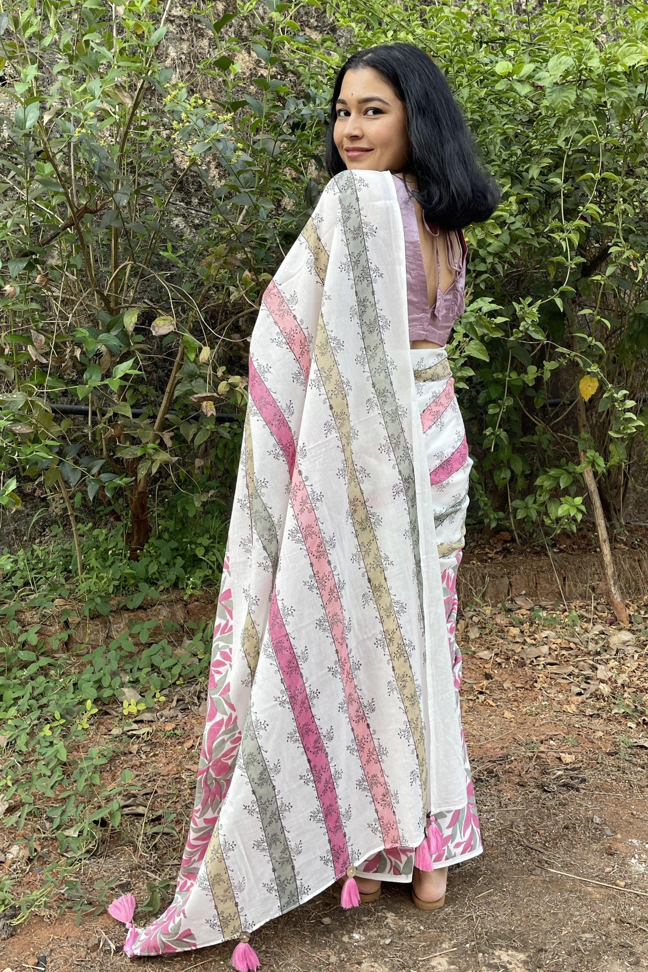 Woman wearing a Mogasu patterned saree outdoors with greenery in the background in Goa