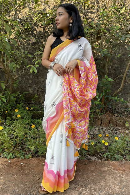 Woman wearing a white Mogasu saree with pink and yellow patterns standing outdoors in Goa.