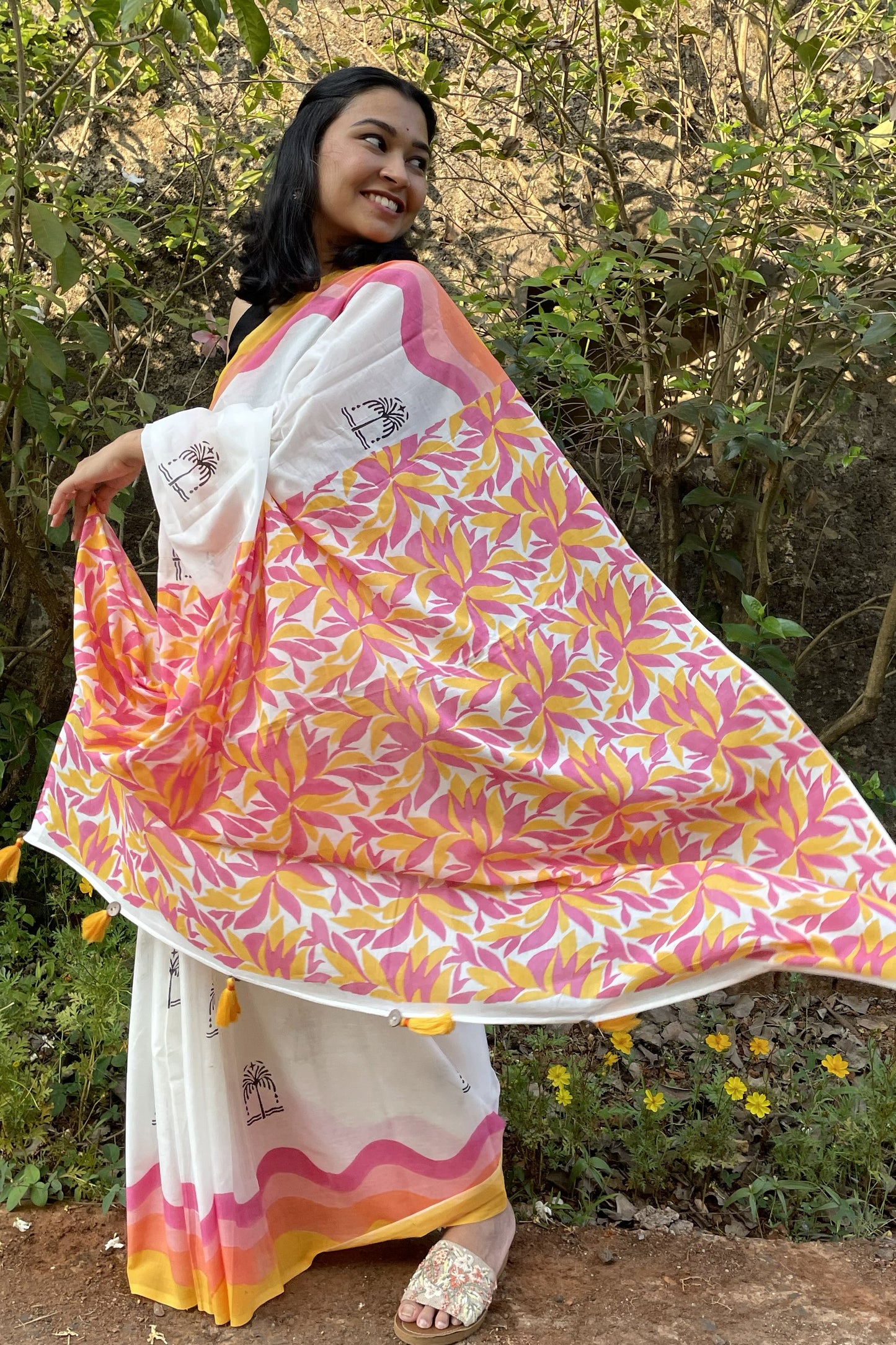 Woman wearing a colorful Mogasu saree with a floral pattern in a natural setting in Goa.