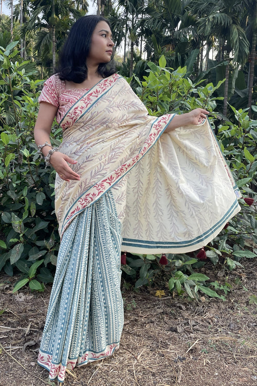 Woman wearing a Mogasu mul cotton saree in a natural setting with greenery.