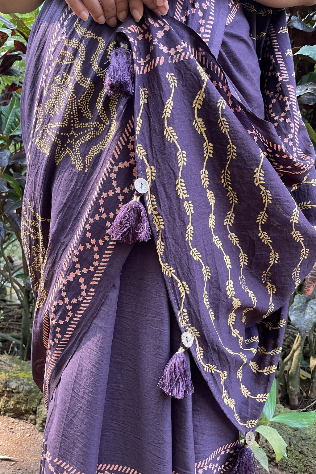 Mogasu’s purple saree with gold patterns and tassels, held by a person against a natural background in Goa