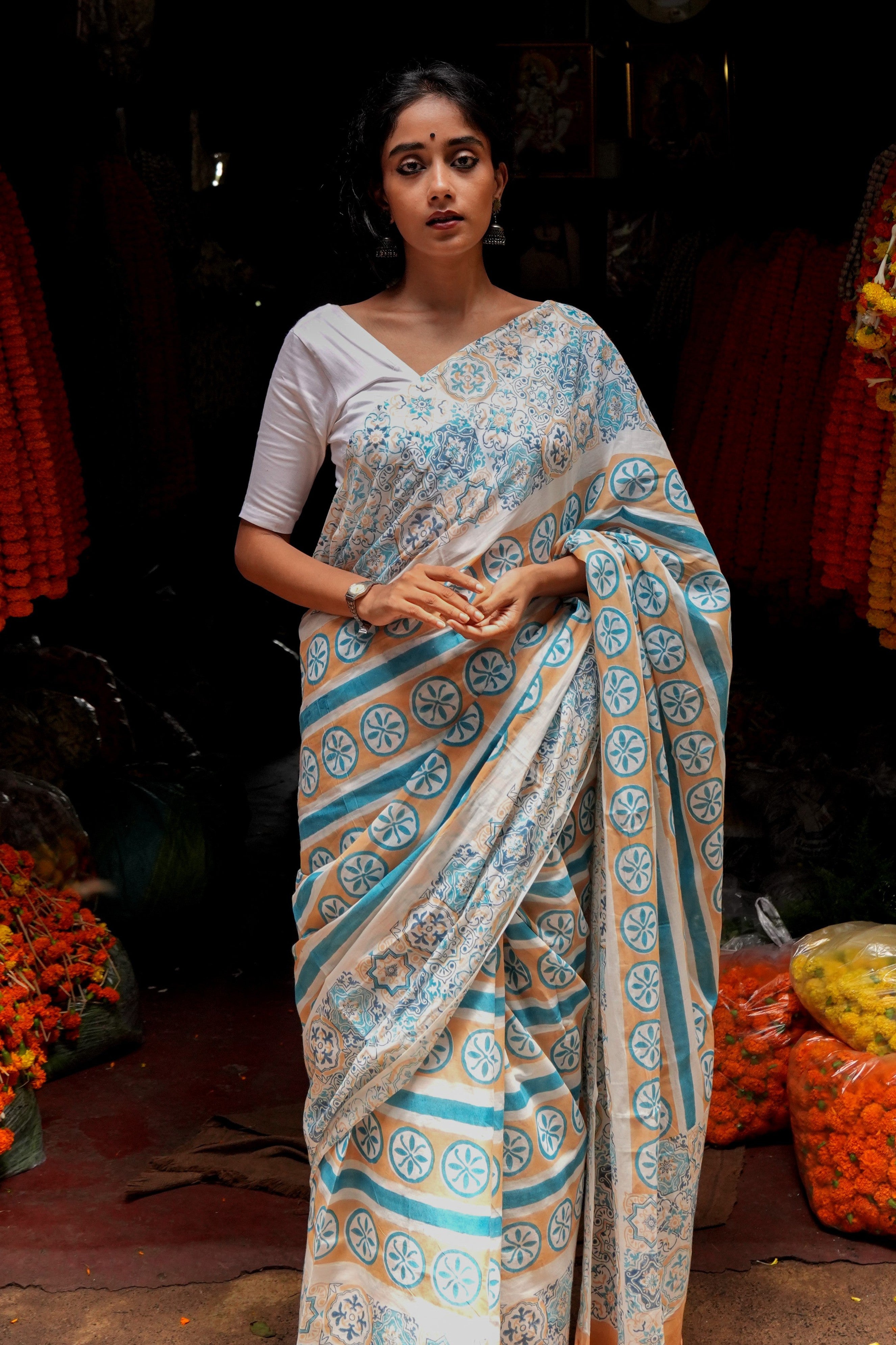 Woman wearing a traditional Goan Azulejo saree in a market setting.