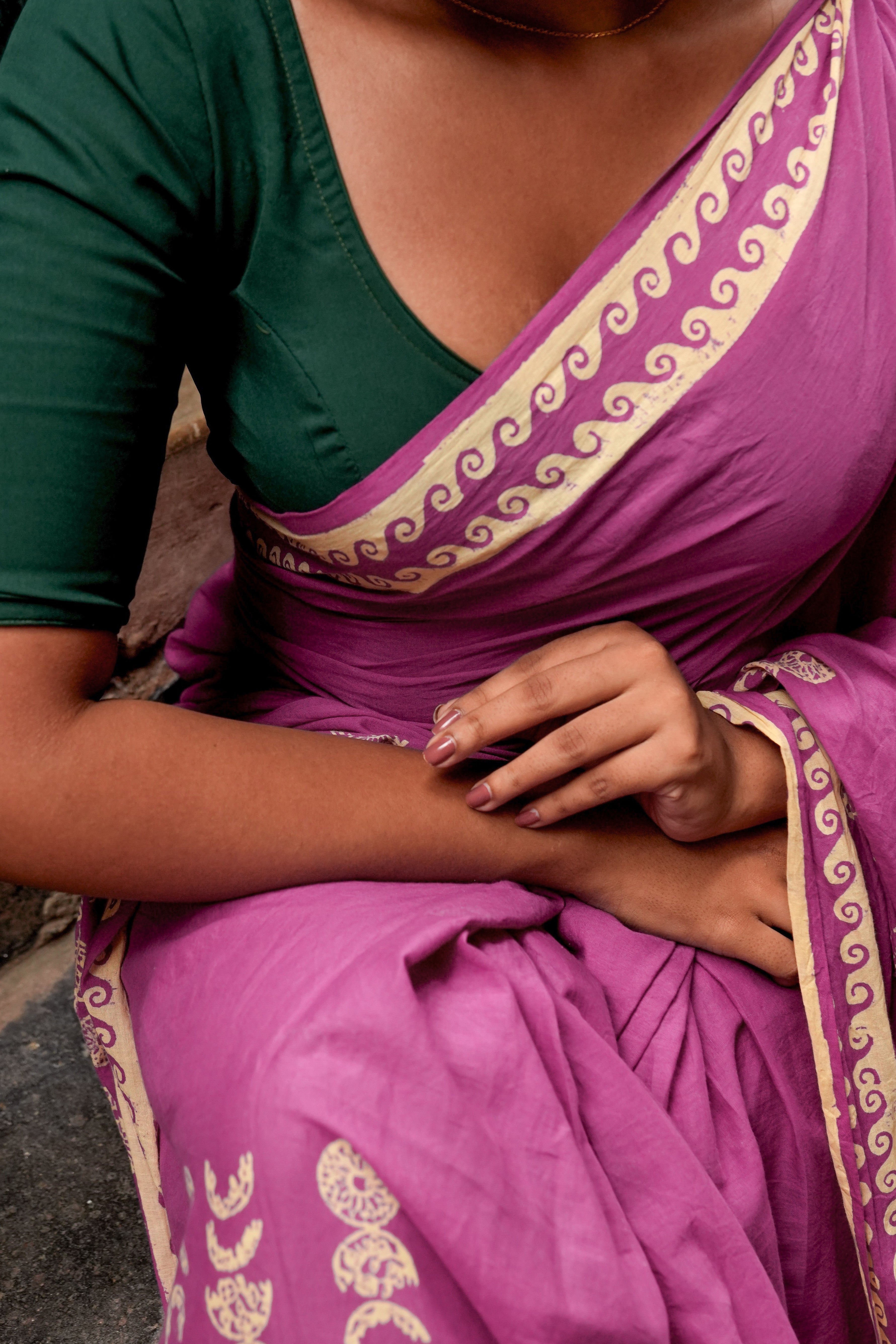 Person wearing a green and pink Mogasu mul cotton saree with intricate patterns