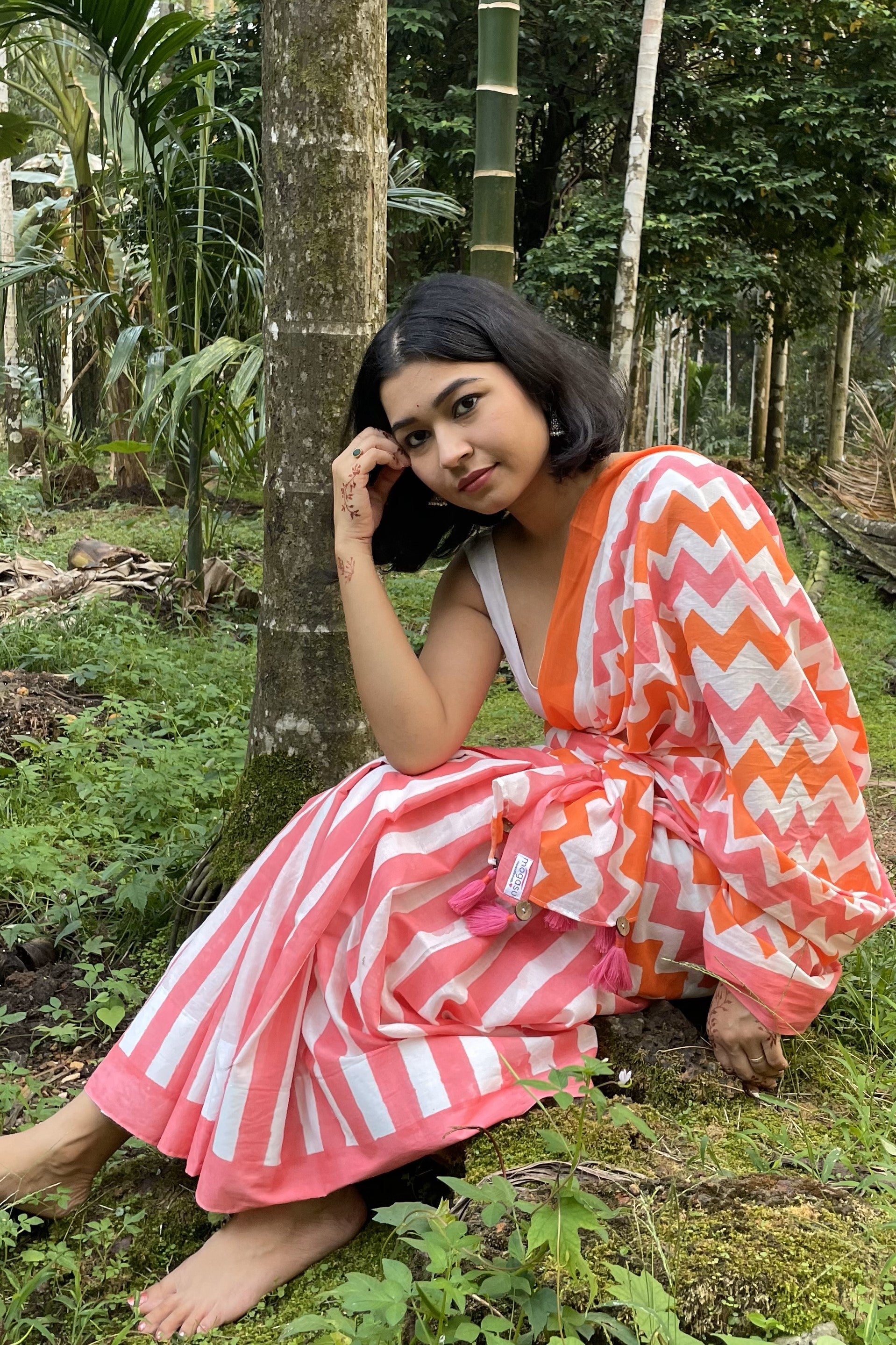 Woman in a colorful Mogasu saree sitting in a forest setting